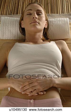 Woman lying on a mat View Large Photo Image Stock Image - Woman lying on a mat. Fotosearch