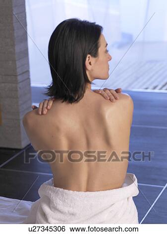 Woman sitting on a massage table, back view View Large Photo Image Stock Photograph - Woman sitting on a massage table, back view. Fotosearch