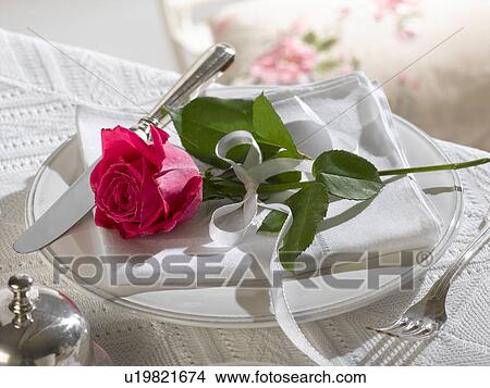 Place setting decorated with a red rose View Large Photo Image Picture - Place setting decorated with a red rose. Fotosearch