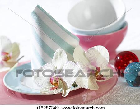 Stock Photo - Place setting with a napkin and white orchid blossoms. Fotosearch
