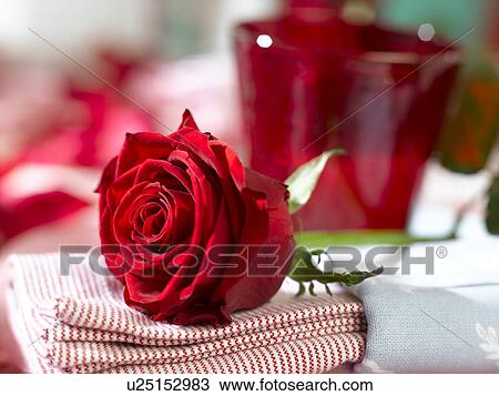 Stock Image - Place setting with a red glass and a red rose. Fotosearch