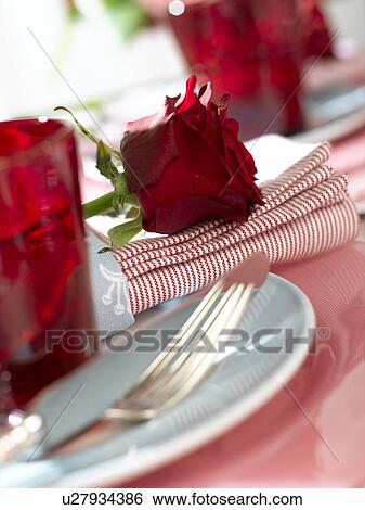 Stock Photograph - Place setting with a red glass and a red rose. Fotosearch