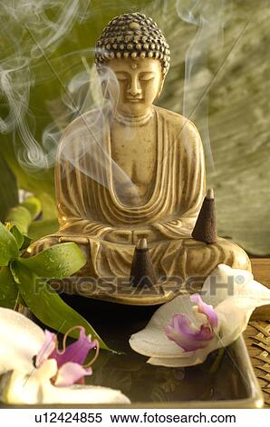 Stock Photography - Buddha with incense cone and orchid blossoms. Fotosearch