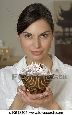Picture - Woman holding a bowl full of blossoms. Fotosearch