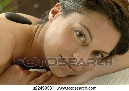 Woman relaxing with pebbles on her back View Large Photo Image Stock Image - Woman relaxing with pebbles on her back. Fotosearch