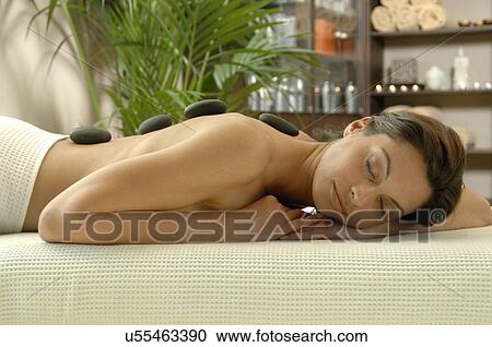 Woman relaxing with pebbles on her back View Large Photo Image Stock Image - Woman relaxing with pebbles on her back. Fotosearch