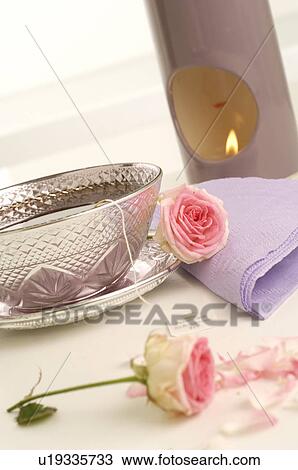 Stock Image - Pink roses, a silver teacup and a aroma lamp. Fotosearch