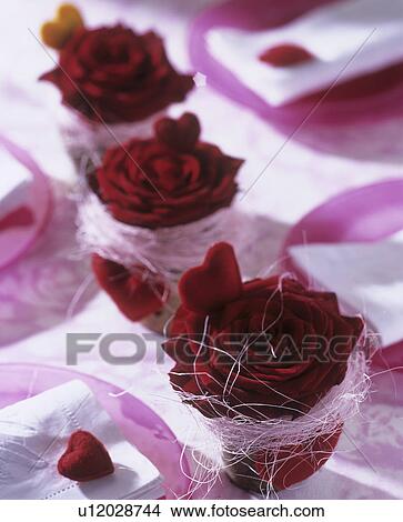 Picture - Table decoration with red roses in small pots and red hearts. Fotosearch