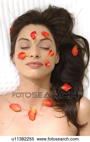 Stock Photography - Woman with petals on her skin. Fotosearch