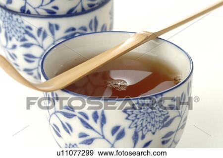 Stock Photo - A cup of tea with a bamboo spoon. Fotosearch