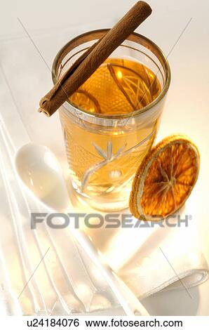 Stock Photograph - A glass of tea with candy stick and a slice of orange. Fotosearch