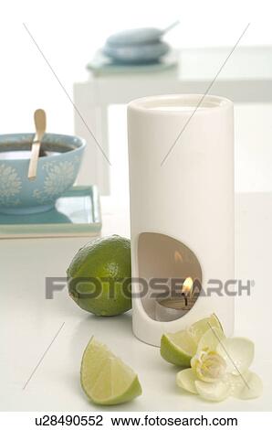 Stock Image - Aroma lamp, limes and orchid blossoms. Fotosearch