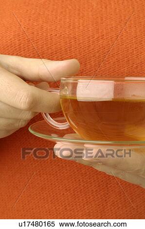 Stock Photography - Cup of St John`s worth tea in a hand. Fotosearch
