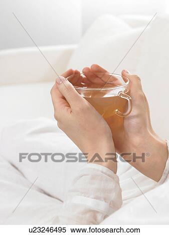 Stock Photography - Tea glass embraced by two hands. Fotosearch