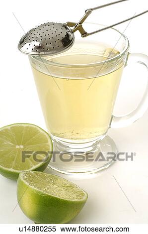Stock Photography - Tea infuser and a tea glass with limes. Fotosearch