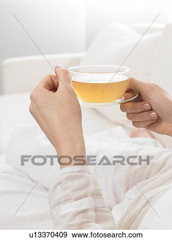Two hands holding a glass of tea View Large Photo Image Stock Photo - Two hands holding a glass of tea. Fotosearch