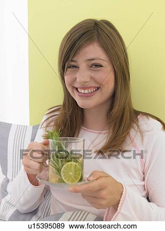Stock Photo - Woman is drinking a cup of lemon tea. Fotosearch