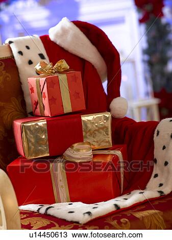 Stock Image - Christmas gifts and Santa Claus jacket and hat. Fotosearch