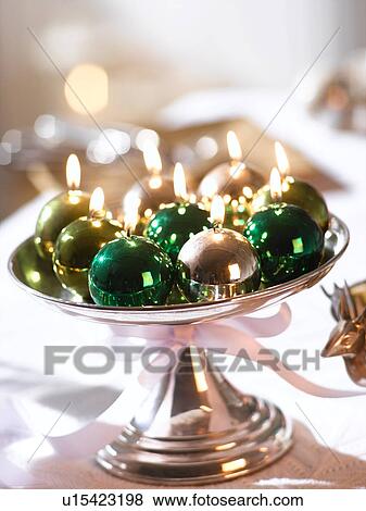 Stock Photo - Glossy Christmas tree ball candles in a silver bowl. Fotosearch