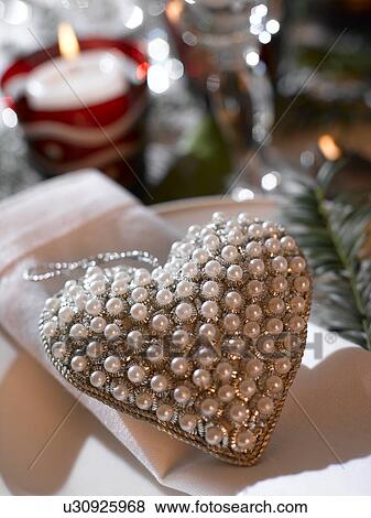 Stock Photo - Napkin and a heart hanger embroided with pearls. Fotosearch