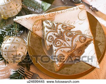Stock Photography - Place cover with a white and golden Christmas tree hanger. Fotosearch
