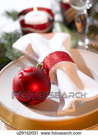 Stock Image - Place cover with a white napkin and a red Christmas tree ball. Fotosearch