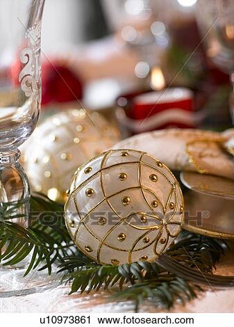 Stock Image - White Christmas tree ball with a golden pattern. Fotosearch