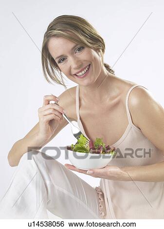 Stock Photograph - Woman is eating salad. Fotosearch