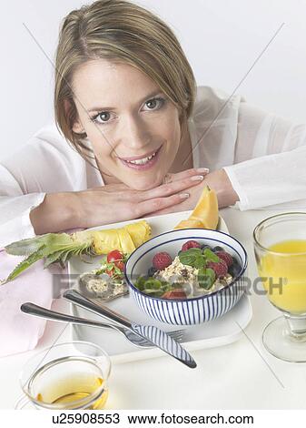Stock Image - Woman is having breakfast with crispbread and cereals. Fotosearch