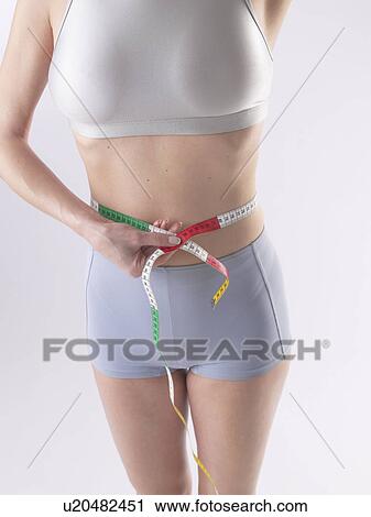 Woman is measuring her waist View Large Photo Image Stock Image - Woman is measuring her waist. Fotosearch