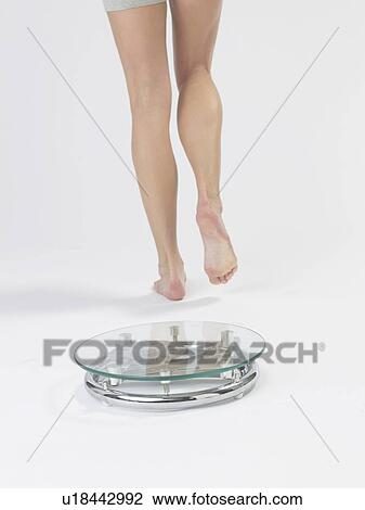 Woman stepping of from the bathroom scale View Large Photo Image Stock Image - Woman stepping of from the bathroom scale. Fotosearch