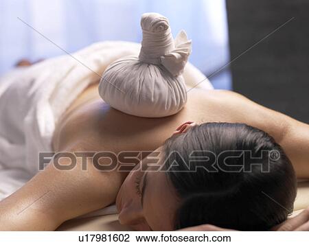 Stock Image - Woman get a massage with a compress. Fotosearch