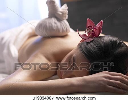 Woman getting a massage with a compress View Large Photo Image Stock Photo - Woman getting a massage with a compress. Fotosearch