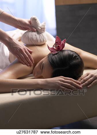 Stock Photo - Woman getting a massage with a compress. Fotosearch