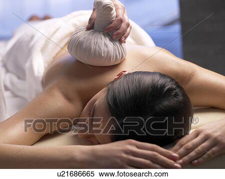 Stock Photography - Woman getting a massage with a compress. Fotosearch