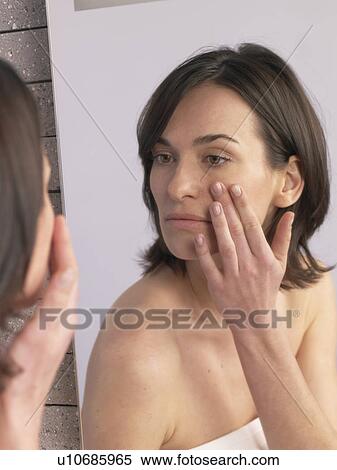 Woman is craming her face View Large Photo Image Stock Photography - Woman is craming her face. Fotosearch