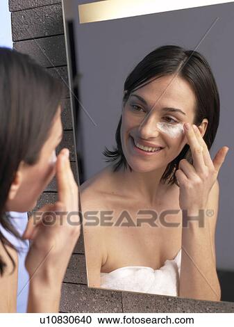 Stock Image - Woman is creaming her face. Fotosearch