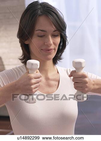 Stock Photo - Woman training with barbells. Fotosearch