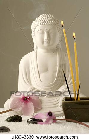 Stock Image - Buddha with viola, hematite, candles, joss sticks. Fotosearch