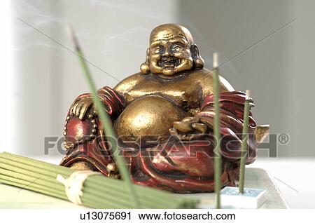 Stock Image - Green Tea joss sticks and Buddha figure. Fotosearch