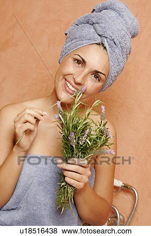 Stock Photo - Woman in the bathroom with a bunch of lavender. Fotosearch