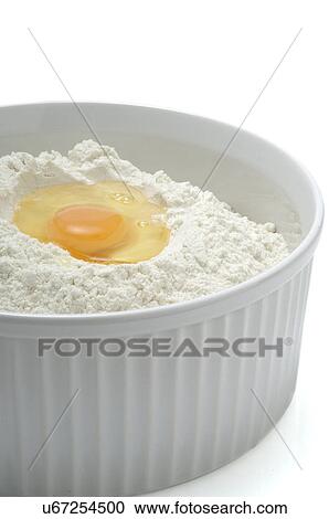 Stock Image - Flour and egg in a bowl. Fotosearch