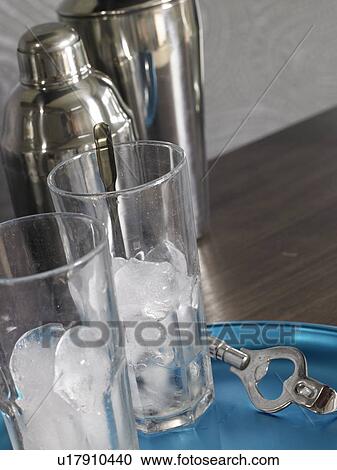 Cocktail bar: Shaker and glasses with ice cubes View Large Photo Image Stock Image - Cocktail bar: Shaker and glasses with ice cubes. Fotosearch
