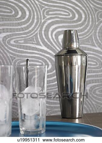 Stock Image - Cocktail bar: Shaker and glasses with ice cubes. Fotosearch