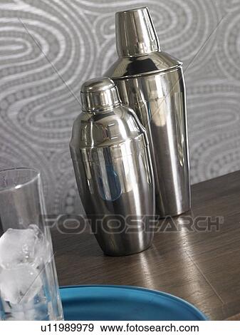 Stock Photo - Cocktail bar: Shaker and glasses with ice cubes. Fotosearch