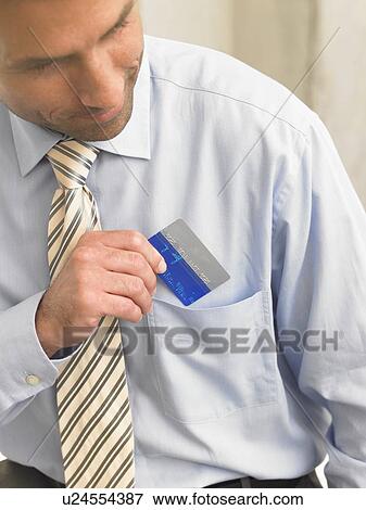 Business man is putting a credit card in his shirt pocket View Large Photo Image Stock Photo - Business man is putting a credit card in his shirt pocket. Fotosearch
