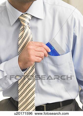 Stock Photograph - Business man is putting a credit card in his shirt pocket. Fotosearch