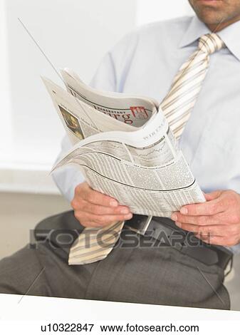 Business man on his desk is reading a newspaper View Large Photo Image Stock Photo - Business man on his desk is reading a newspaper. Fotosearch