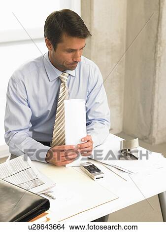 Picture - Business man on his desk. Fotosearch