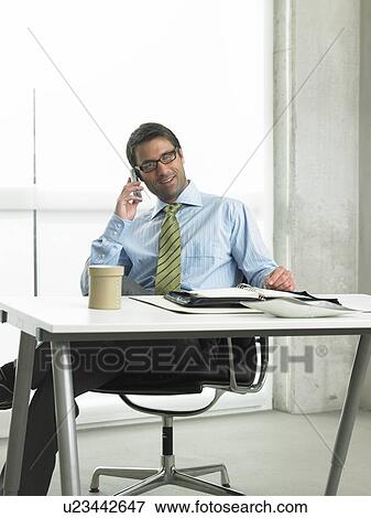Business man on his desk View Large Photo Image Stock Photo - Business man on his desk. Fotosearch